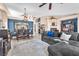 Comfortable living room features a cozy gray sectional sofa, dining area and decorative fireplace at 10113 Walhalla Plateau Ct, Las Vegas, NV 89148