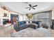 Spacious living room with a corner fireplace, plush sectional, tile flooring, and lots of natural light at 10113 Walhalla Plateau Ct, Las Vegas, NV 89148