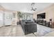 Bright living room featuring a plush gray sectional sofa, tiled flooring, and a large entertainment center at 10113 Walhalla Plateau Ct, Las Vegas, NV 89148