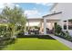 Backyard view with artificial grass, covered patio, outdoor kitchen, dining area, and inviting lounge seating at 10196 Sequoia Glen Ave, Las Vegas, NV 89166