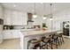 Well-lit kitchen with a center island, white cabinets, stainless appliances and an integrated wine fridge for entertaining at 10196 Sequoia Glen Ave, Las Vegas, NV 89166