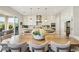 Open-concept kitchen with seating at the island, wine fridge, white cabinetry, and glass doors to the outdoor patio at 10196 Sequoia Glen Ave, Las Vegas, NV 89166