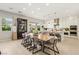 Spacious kitchen and dining area with long center island, stainless appliances, pendant lighting and neutral color palette at 10196 Sequoia Glen Ave, Las Vegas, NV 89166