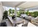 A stylish covered patio features an outdoor dining table, lounge area, and lush greenery at 10196 Sequoia Glen Ave, Las Vegas, NV 89166