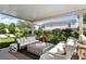 Covered patio with chic seating, outdoor rug, and views of the manicured landscaping and lush backyard at 10196 Sequoia Glen Ave, Las Vegas, NV 89166