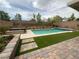 Landscaped backyard oasis featuring a sparkling pool, spa, lush artificial turf, and beautiful stonework at 10331 Northern Hills Ave, Las Vegas, NV 89166