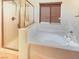 Bright bathroom featuring a glass-enclosed shower, soaking tub and brown wood window blinds at 10331 Northern Hills Ave, Las Vegas, NV 89166