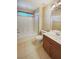 Bright bathroom features a tub/shower combo, toilet, vanity, tile flooring, and natural light from the window at 10331 Northern Hills Ave, Las Vegas, NV 89166