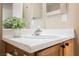 Bathroom vanity with white countertop, wooden cabinet and faucet at 10400 Beautiful Fruit St, Las Vegas, NV 89183