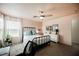 Comfortable bedroom features a ceiling fan, a comfortable bed with blue pillows, and natural light at 10400 Beautiful Fruit St, Las Vegas, NV 89183