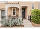 Inviting front porch with table and chairs, desert landscaping, decorative front door and tiled roof at 10400 Beautiful Fruit St, Las Vegas, NV 89183