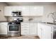 Bright kitchen with stainless steel appliances, white cabinets, and wood-look flooring at 10400 Beautiful Fruit St, Las Vegas, NV 89183