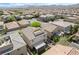 Expansive aerial view of a Primary-planned community with beige homes, tile roofs and mountain views at 10565 Olinda St, Las Vegas, NV 89179