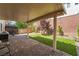 Charming backyard featuring a covered patio, lush artificial grass, and brick pavers, perfect for outdoor living and entertaining at 10565 Olinda St, Las Vegas, NV 89179