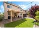Lush backyard features artificial turf, brick pavers, and an outdoor kitchen setup under a pergola for easy entertaining at 10565 Olinda St, Las Vegas, NV 89179