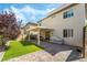 Landscaped backyard featuring artificial grass, a brick patio, and a covered seating area, perfect for outdoor living at 10565 Olinda St, Las Vegas, NV 89179