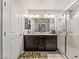Bright bathroom features a glass-enclosed shower, double sinks and a modern vanity with dark brown cabinets at 10565 Olinda St, Las Vegas, NV 89179