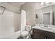 Bright bathroom features a shower-tub combo and a modern vanity with a white countertop and dark brown cabinets at 10565 Olinda St, Las Vegas, NV 89179