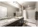 Bright bathroom features a shower-tub combo, double sinks, granite countertops, and dark brown cabinets at 10565 Olinda St, Las Vegas, NV 89179