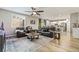 Open-concept living room features wood floors, a ceiling fan, and access to the kitchen at 10565 Olinda St, Las Vegas, NV 89179
