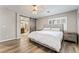 Bright main bedroom featuring a ceiling fan, shutters, wood-look flooring, and barn door to bath at 10565 Olinda St, Las Vegas, NV 89179