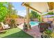 Private backyard features lush green turf, a water feature and a view of the pool and spa at 10823 Drake Ridge Ave, Las Vegas, NV 89166