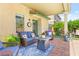 Cozy covered patio featuring comfortable wicker furniture and a lush, landscaped backyard at 10823 Drake Ridge Ave, Las Vegas, NV 89166