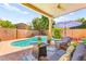 Lush backyard with a pool, spa, patio furniture, and covered patio with ceiling fan at 10823 Drake Ridge Ave, Las Vegas, NV 89166