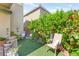 Charming backyard retreat with green turf, potted plants, and mature roses and foliage at 10823 Drake Ridge Ave, Las Vegas, NV 89166