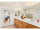 Bathroom with double sinks, wood cabinets, and tile flooring at 10823 Drake Ridge Ave, Las Vegas, NV 89166