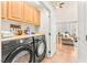 Well-lit laundry area with modern appliances, wooden cabinets, and a folding counter at 10823 Drake Ridge Ave, Las Vegas, NV 89166