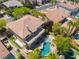 A birds-eye shot of a home and pool, showcasing the home's balcony, green artificial turf, and lovely backyard landscaping at 11237 Campsie Fells Ct, Las Vegas, NV 89141