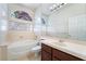 A bright bathroom featuring a tub, shower with glass block window, and a single sink vanity at 11237 Campsie Fells Ct, Las Vegas, NV 89141