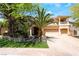 Inviting home with lush landscaping, palm trees, and a brick driveway leading to a three-car garage at 11237 Campsie Fells Ct, Las Vegas, NV 89141