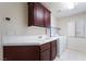 A functional laundry room featuring tile counters, sink, cabinets, and washer/dryer hookups at 11237 Campsie Fells Ct, Las Vegas, NV 89141