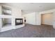 Living room with fireplace and staircase, neutral carpet, and ample lighting at 11237 Campsie Fells Ct, Las Vegas, NV 89141