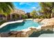 Beautiful backyard pool with rock features and lush landscaping, perfect for outdoor entertaining and relaxation at 11237 Campsie Fells Ct, Las Vegas, NV 89141