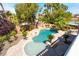 This backyard boasts a beautiful rock pool and spa with mature landscaping and lush, mature trees at 11237 Campsie Fells Ct, Las Vegas, NV 89141