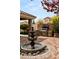 Charming backyard featuring a brick patio, tiered fountain, and outdoor kitchen with a built-in grill, perfect for entertaining at 11578 Suburban Rd, Las Vegas, NV 89135