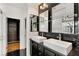Bright bathroom with double sinks, modern fixtures, and elegant black marble accents at 11578 Suburban Rd, Las Vegas, NV 89135