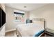 Cozy bedroom with hardwood floors, a queen-size bed, and a window offering a view of the neighborhood at 11578 Suburban Rd, Las Vegas, NV 89135