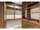 Organized walk-in closet with wooden shelving, drawers, and rods, providing ample storage and a touch of elegance at 11578 Suburban Rd, Las Vegas, NV 89135
