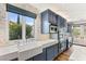 Bright kitchen with marble countertops, oversized window with a view, and custom blue cabinets at 11578 Suburban Rd, Las Vegas, NV 89135
