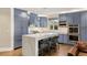 Spacious kitchen features an island with seating, stainless steel appliances, and blue custom cabinets at 11578 Suburban Rd, Las Vegas, NV 89135
