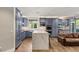 Open-concept kitchen with stainless appliances, custom blue cabinets, an island, and hardwood floors at 11578 Suburban Rd, Las Vegas, NV 89135
