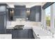Gourmet kitchen with marble countertops, gas cooktop, custom grey cabinets and stainless steel appliances at 11578 Suburban Rd, Las Vegas, NV 89135