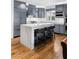 Spacious kitchen features an island with seating, stainless steel appliances, and grey custom cabinets at 11578 Suburban Rd, Las Vegas, NV 89135