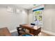 Stylish office with a modern desk, hardwood floors, and a large arched window, creating a bright workspace at 11578 Suburban Rd, Las Vegas, NV 89135