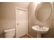 Small bathroom featuring a toilet and pedestal sink with a round mirror hanging above at 11900 Calle De Sol Dr, Las Vegas, NV 89138