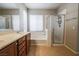 Bright bathroom with double sinks, bathtub, and glass-enclosed shower at 11900 Calle De Sol Dr, Las Vegas, NV 89138